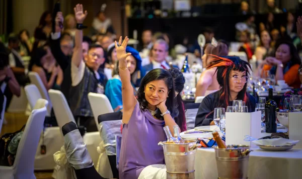 Ball supporters raising their hands to donate to masculinity norms research and consent education for youths. Photograph by Wesley Loh / Memphis West Pictures.