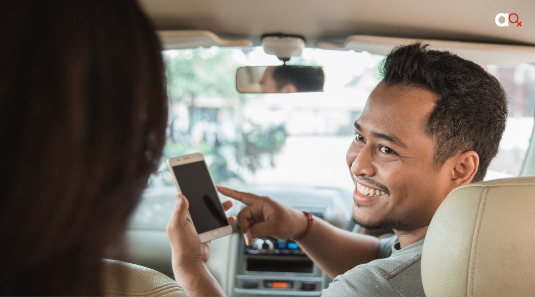 A driver, who is a platform worker, pointing at his phone.